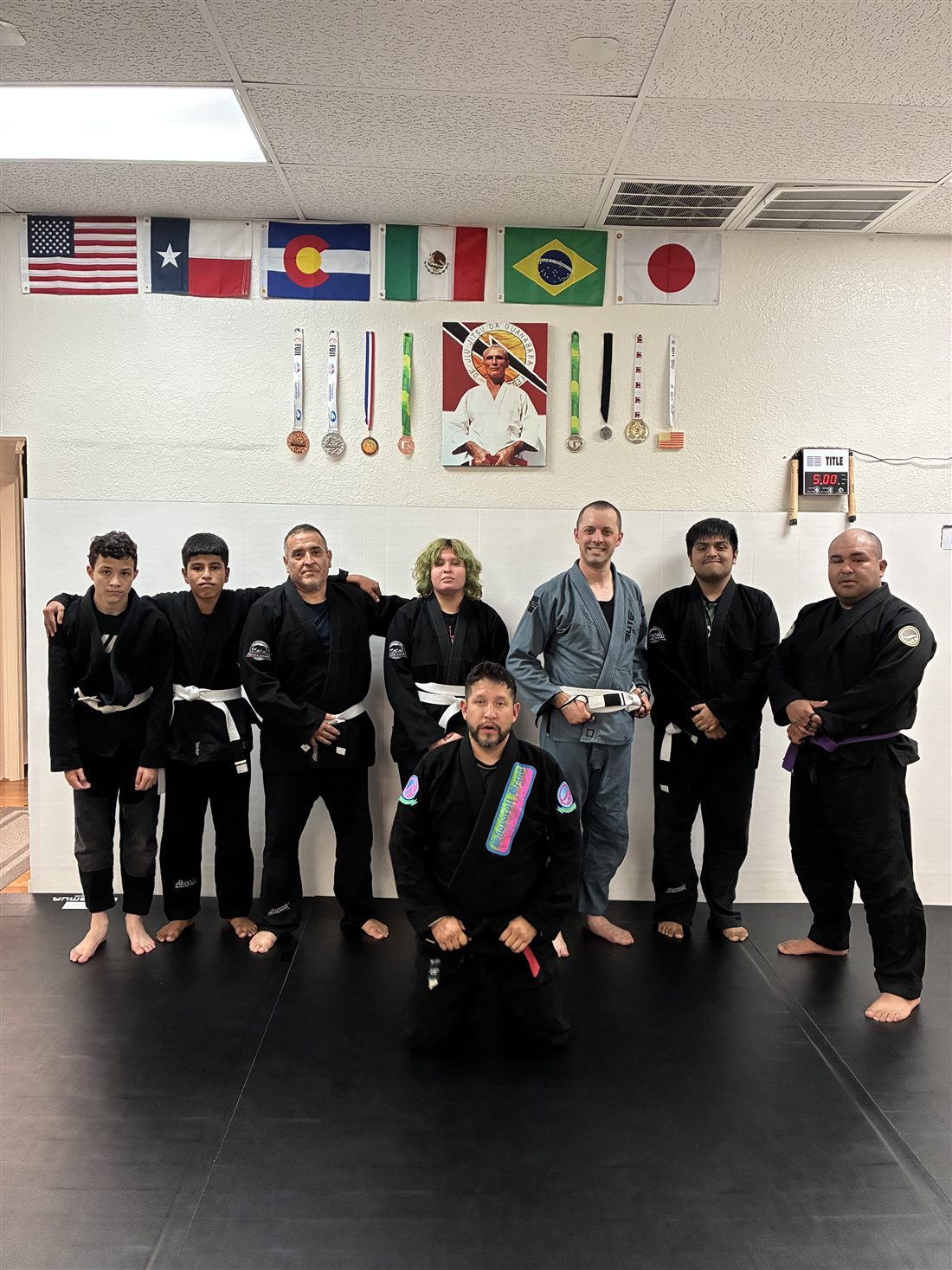 Brazilian Jiu-Jitsu students and coaches lined up on the mats
